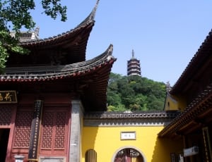 red and yellow concrete temple near green trees during daytime thumbnail