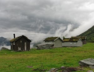 three grey and brown house near mountain during daytime thumbnail