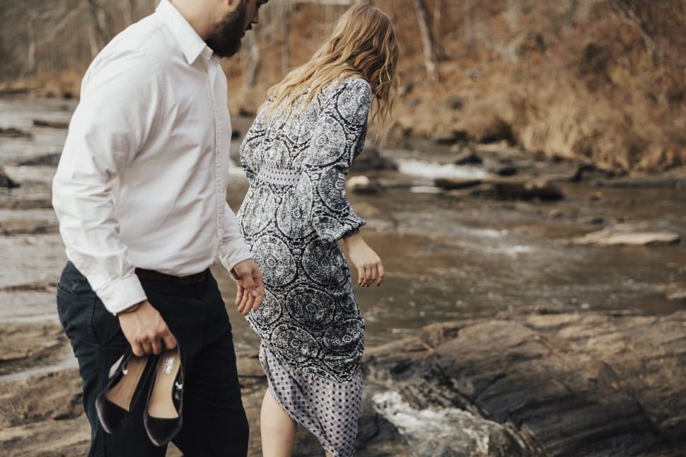 selective focus photography of man and woman near river preview