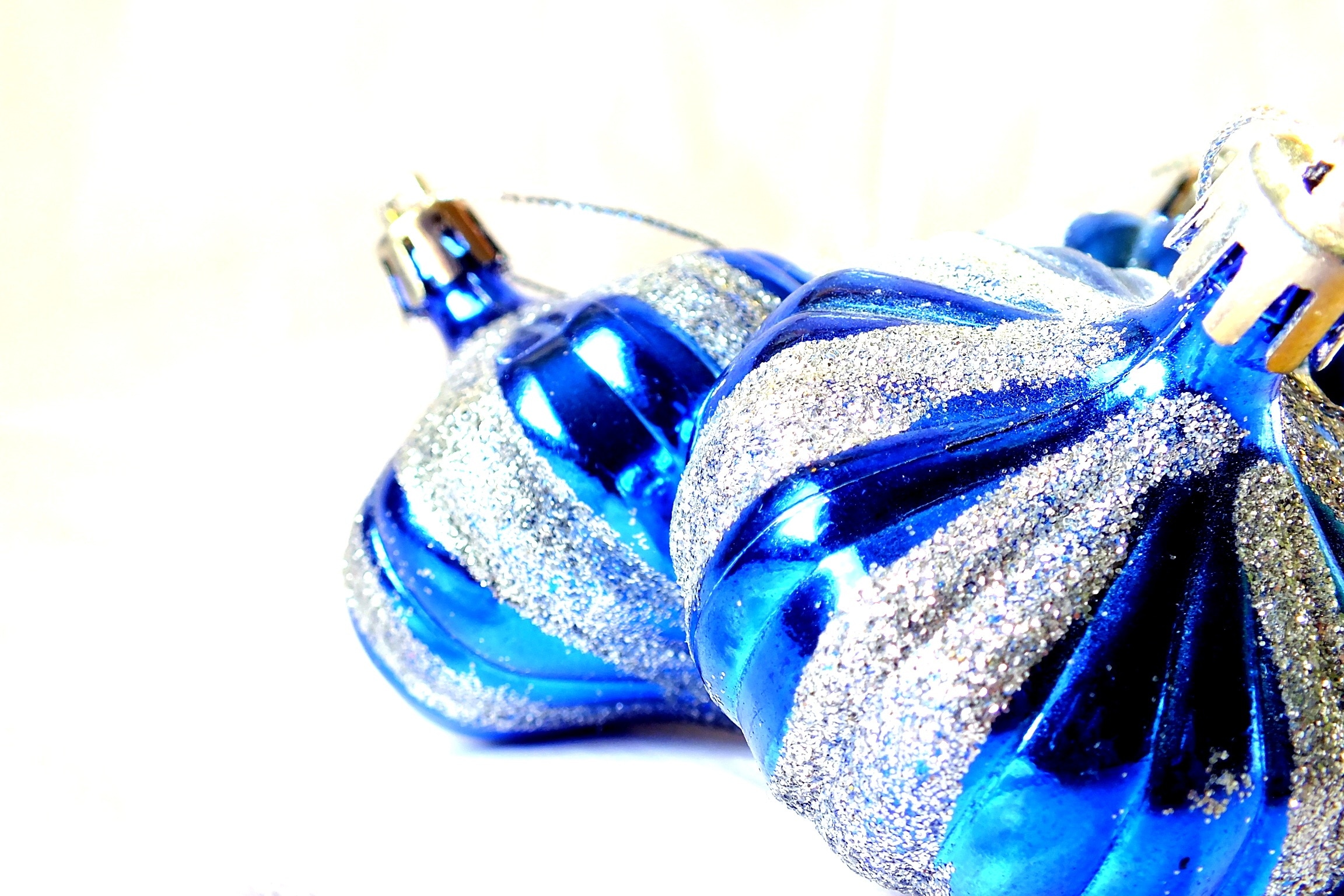 2 blue and gray glittered baubles