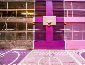white and brown basketball board mounted in purple concrete high rise building thumbnail