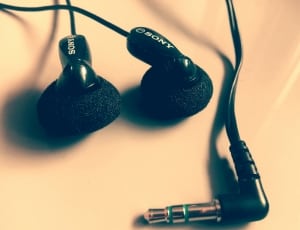 closeup photo of black Sony earphones on beige panel thumbnail