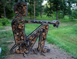 black metal frame brown firewoods shaped as sitting person thumbnail