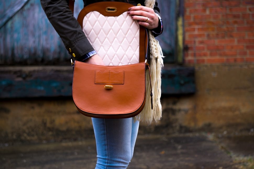 woman wearing brown and white saddle bag preview