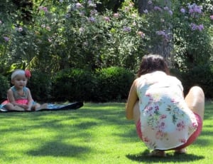 two woman near baby in pink dress on garden under clear sky during daytime thumbnail