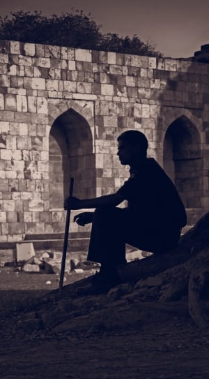 silhouette of a man sitting holding stick thumbnail