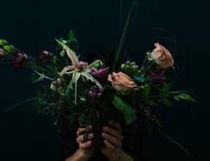 person holding purple and pink flowers thumbnail