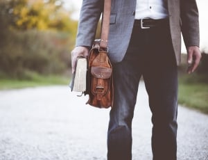 person wearing gray suit jacket  carrying book thumbnail