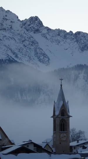 grey concrete church beside snow mountains thumbnail