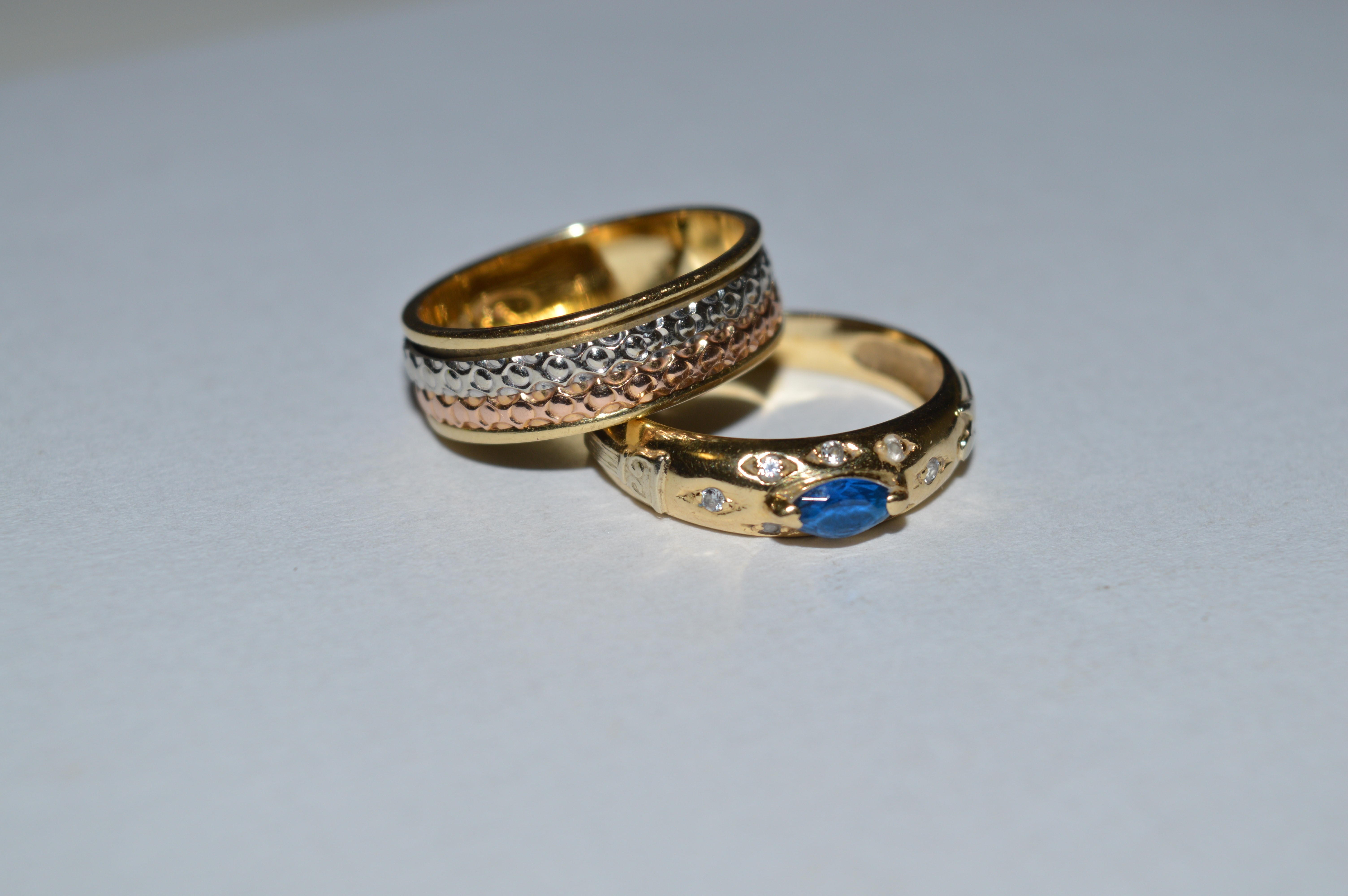 gold band and gold with blue gemstone ring