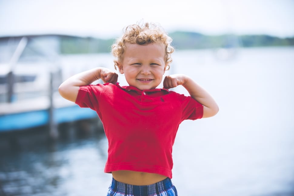 toddler wearing red collared shirt near body of water preview