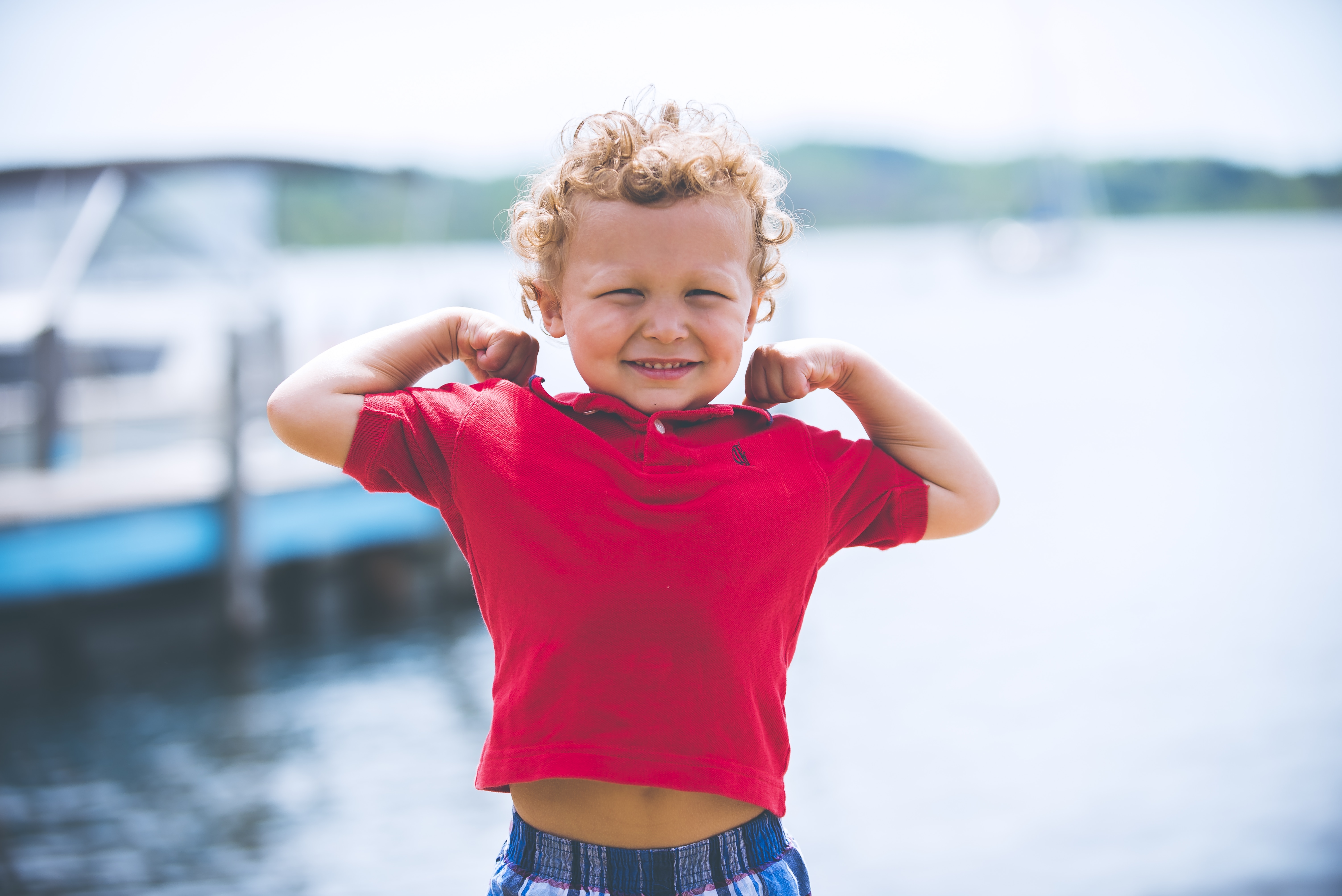 toddler wearing red collared shirt near body of water