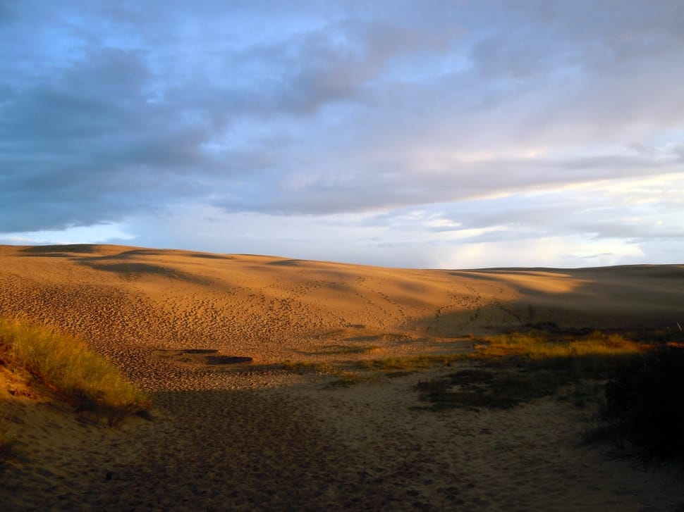 brown desert under grey sky during daytime preview