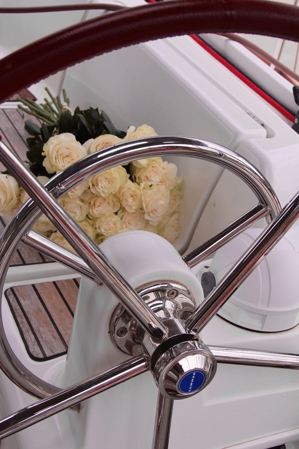 white rose bouquet beside boat steering wheel preview