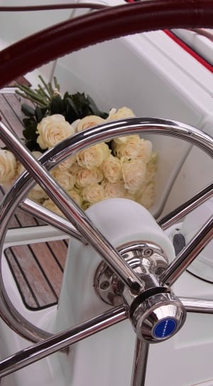 white rose bouquet beside boat steering wheel thumbnail