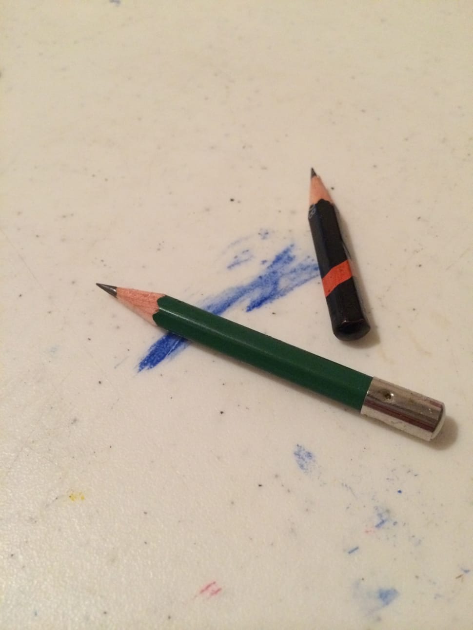 two black and green pencils on white surface preview