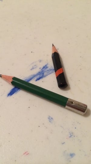 two black and green pencils on white surface thumbnail
