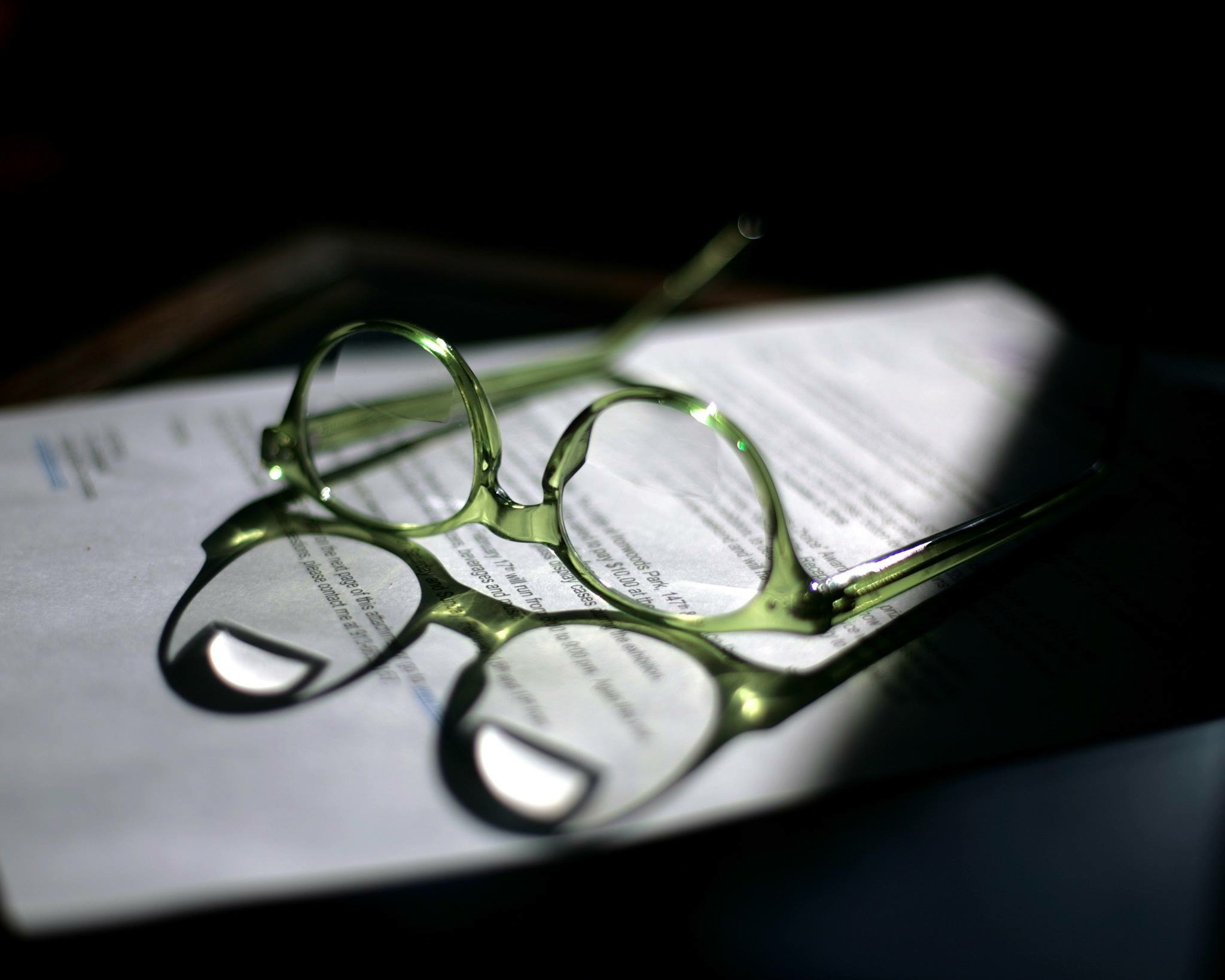 green frame eyeglasses on white printed paper
