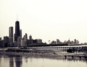 grayscale photo of city beside body of water thumbnail