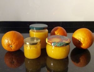 3 orange citrus fruits and clear glass container thumbnail