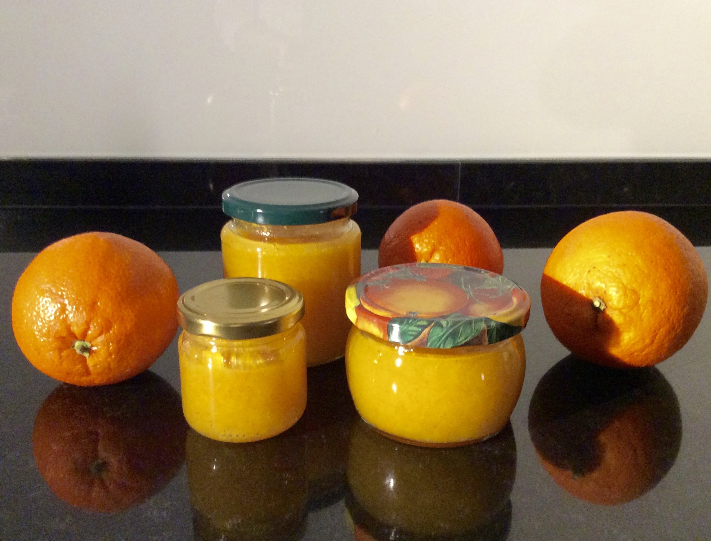 3 orange citrus fruits and clear glass container