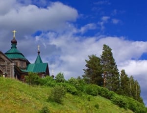 brown and green church on the mountain during day time thumbnail