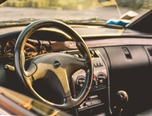 black car steering wheel inside car thumbnail