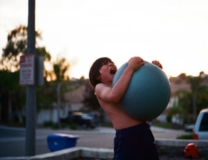 boy hugging tightly to stability ball thumbnail