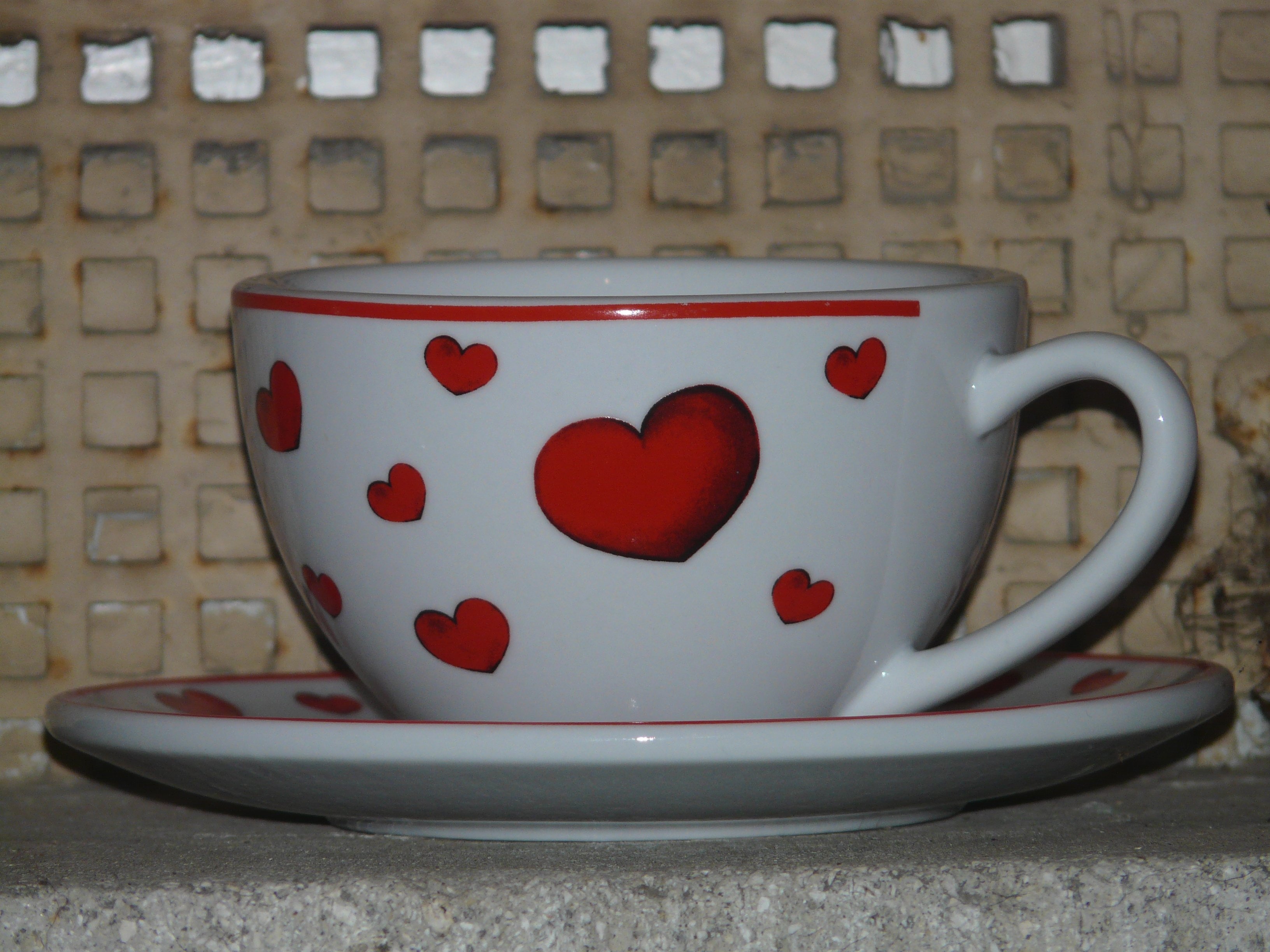 white and  red ceramic heart carved teacup and saucer
