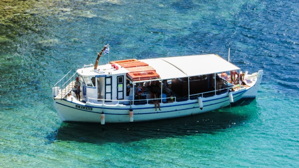 white and blue ferry boat on blue and green body of water during daytime preview