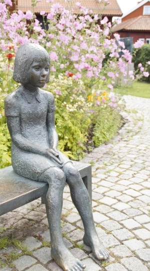 girl gray statue sitting on the bench at the park during daytime thumbnail