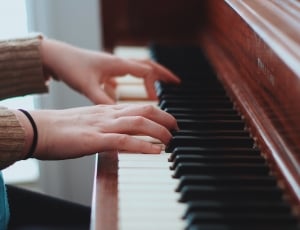 person in gray sweater playing piano thumbnail