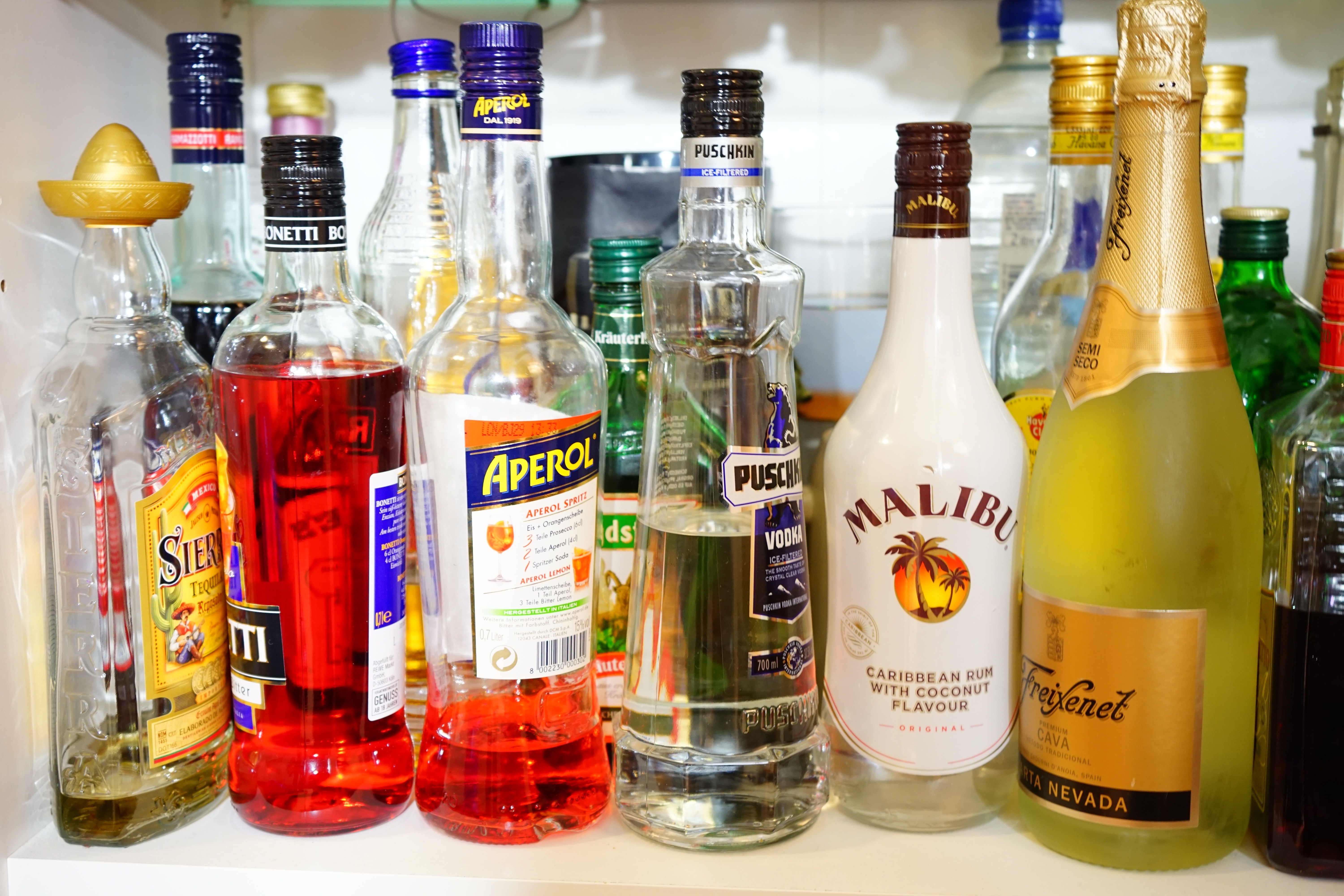 liquor bottle collection on white shelf