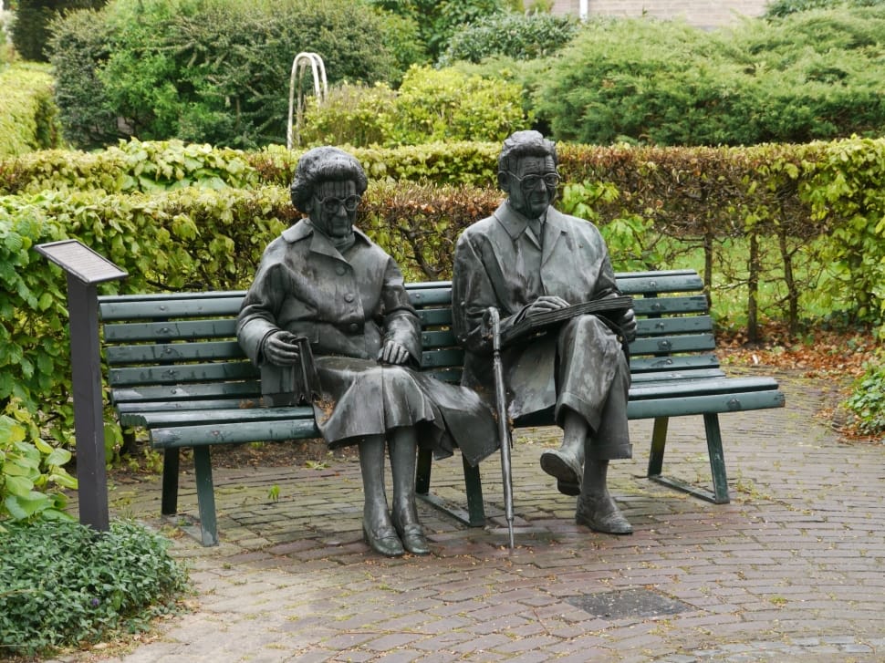 man and woman sitting on bench statues preview