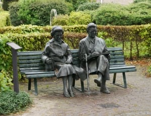 man and woman sitting on bench statues thumbnail