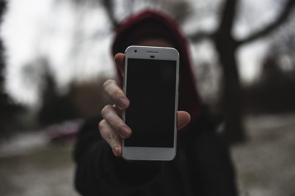 woman wearing black coat holding white smartphone preview