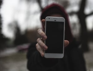 woman wearing black coat holding white smartphone thumbnail