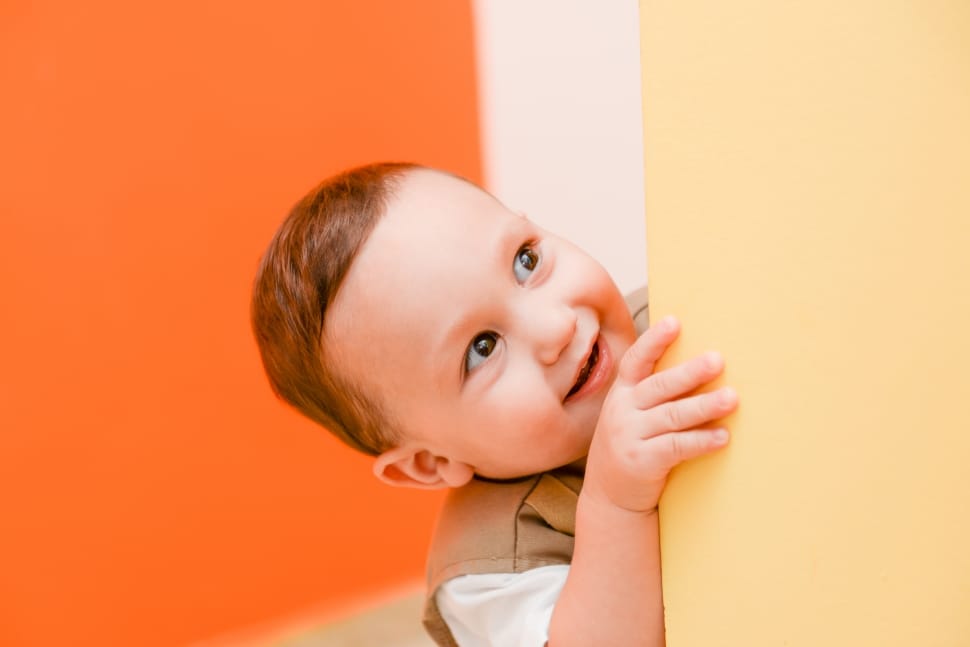boy's grey and white shirt behind orange wall paint inside the room preview