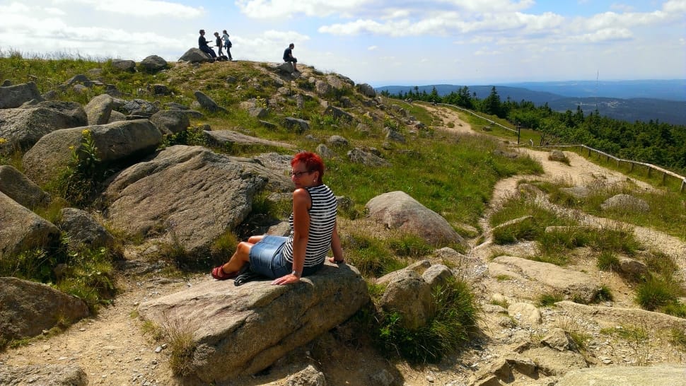 red haired man sitting on gray rock preview