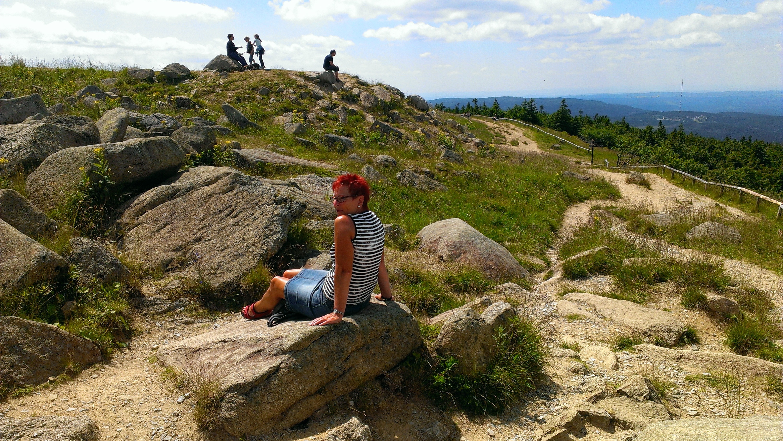 red haired man sitting on gray rock