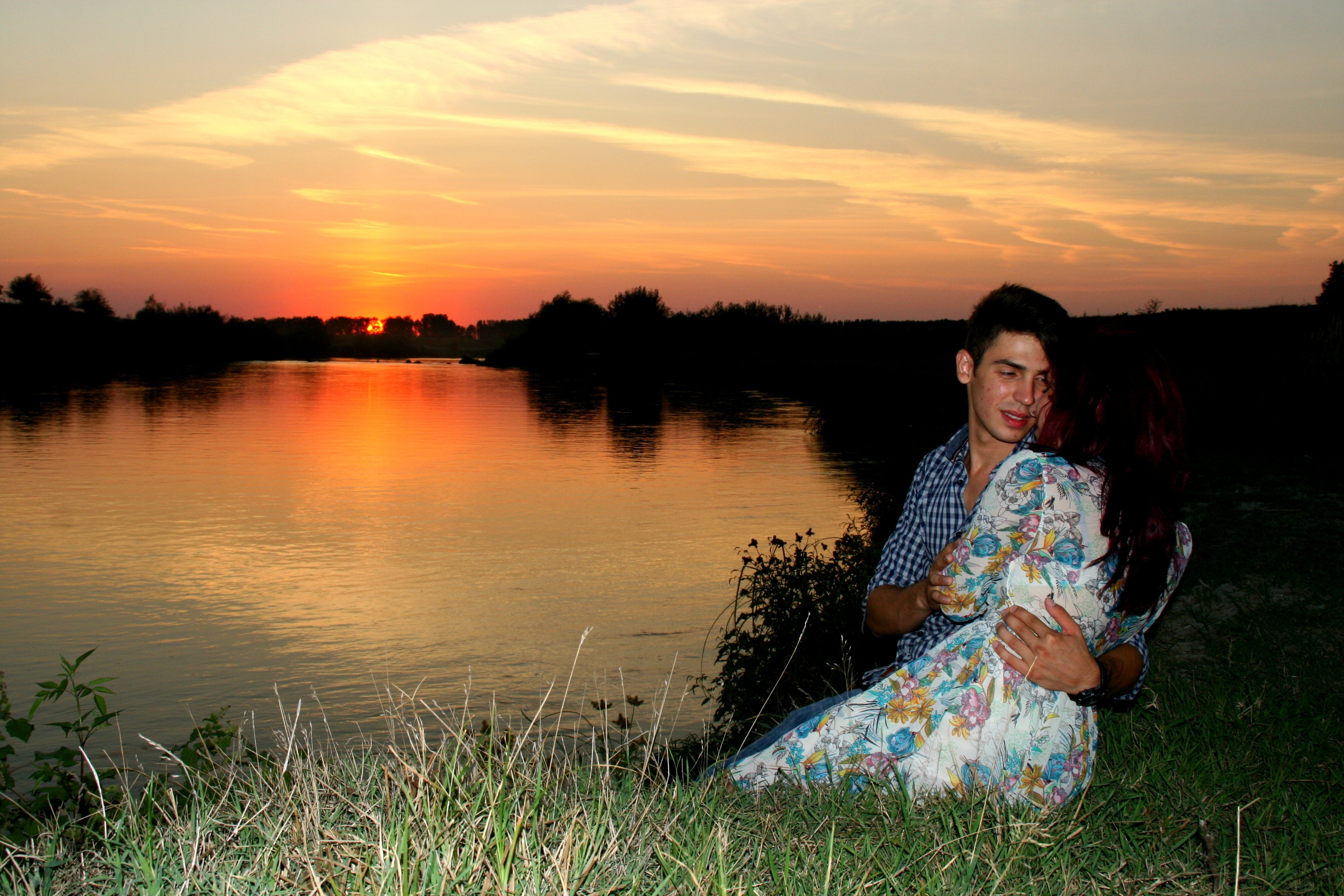 man and woman sitting in green grass