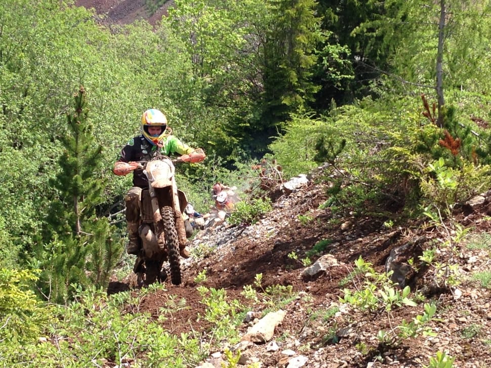 human riding on the motocross dirt bike on the mountain during daytime preview