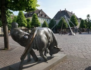 man pulling buffalo statue thumbnail