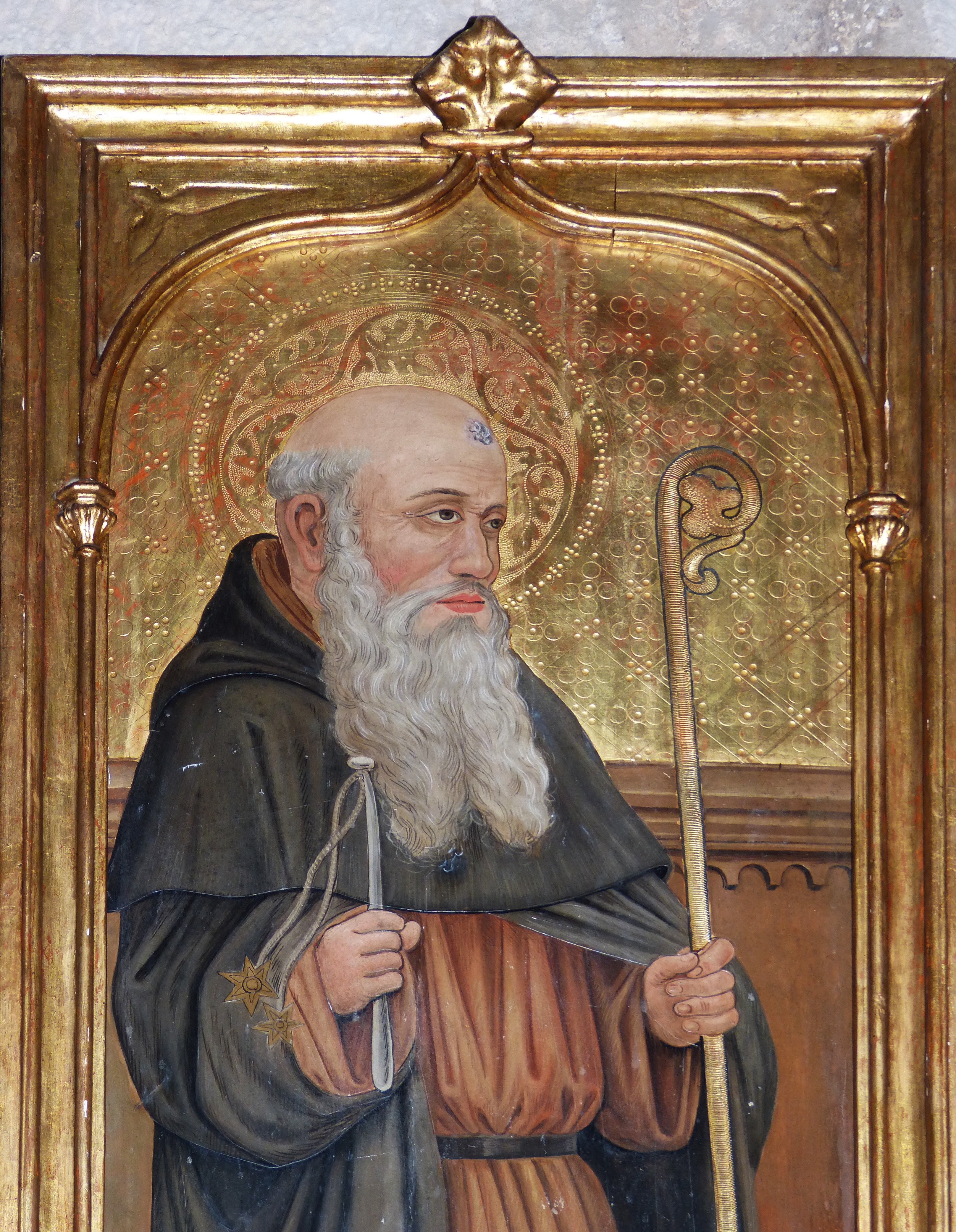 brass framed illustration of priest holding cane