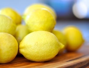 yellow lemon on top brown wooden surface ]\ thumbnail