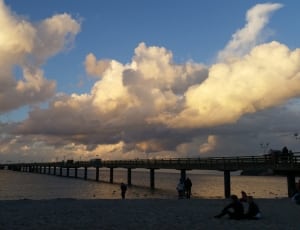 silhouette of bridge under cloudy sky during daytime thumbnail
