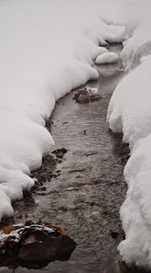 snow pile beside river thumbnail