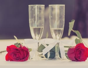 2 clear champagne glass and red roses flower thumbnail
