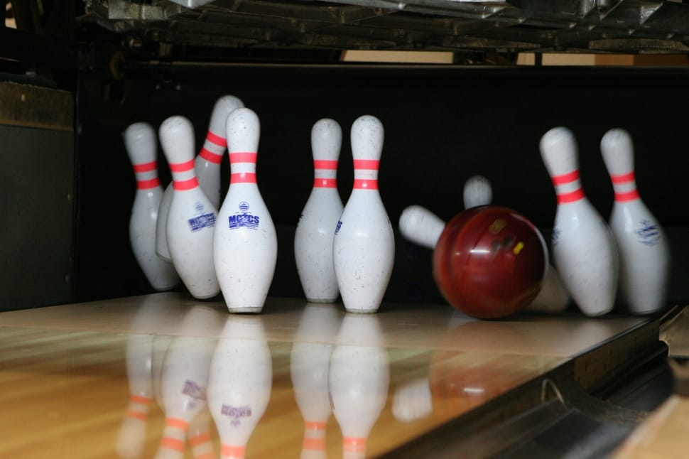 red bowling ball crashes on white bowling pins preview