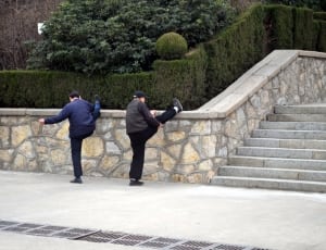 two man lifting feet on gray concrete wall thumbnail